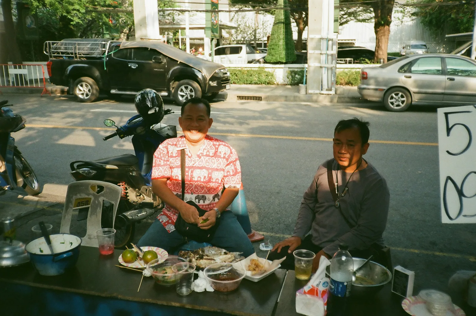 Street food prices chalked at a Phuket food stall with plates under 100 baht