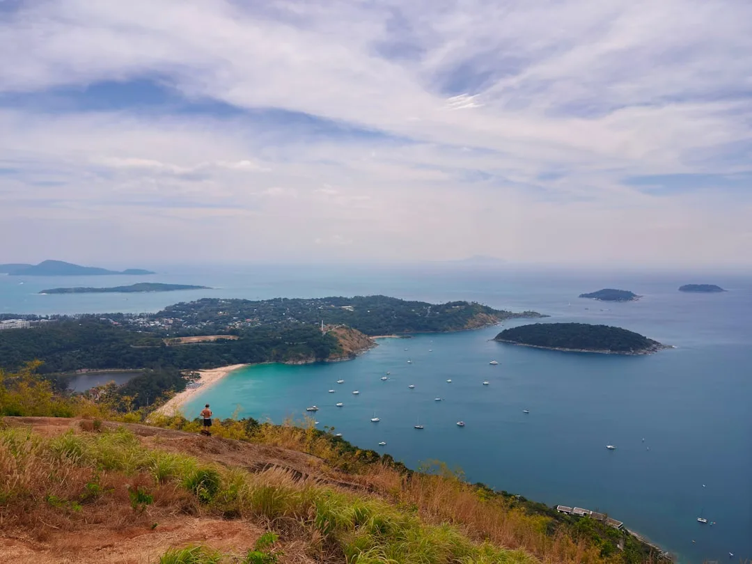 Karon Beach Phuket, fine white sand stretches along the bay with palm trees and the Andaman Sea at sunset