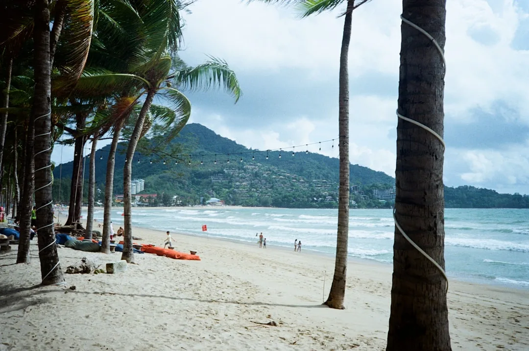 Patong Beach Phuket at sunrise, 2.85 km of white sand with turquoise Andaman Sea and jungle hills behind