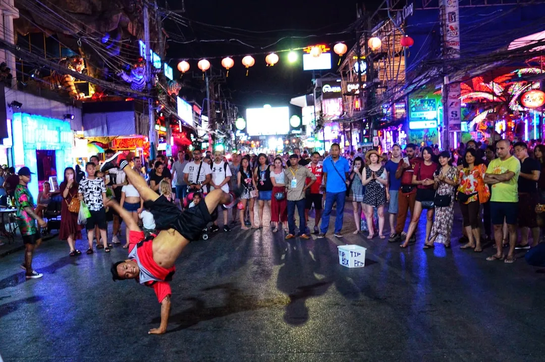 Phuket nightlife low season – glowing bar fronts reflected in rain-slicked pavement on a quiet evening street