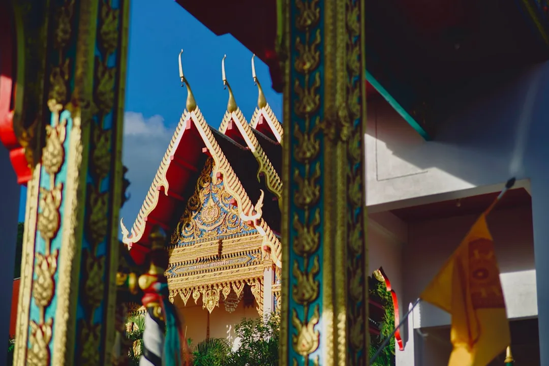 Wat Chalong Phuket golden Phra Mahathat Chedi grand pagoda rising above temple grounds at sunrise
